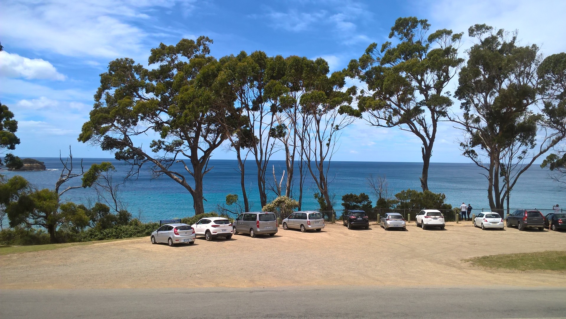 Area parcheggio sul mare con alberi e cielo azzurro
