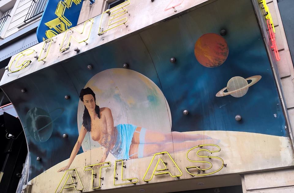 Facciata del cinema Atlas con donna e pianeti