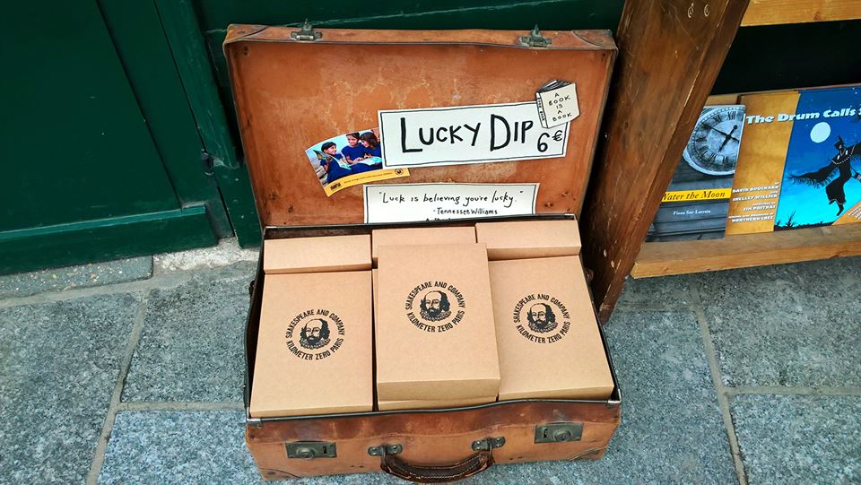Valigia con libri della libreria Shakespeare in confezioni anonime, e scritta "Lucky Dip"