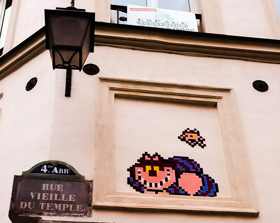 Uno Stregatto di mattonelle su un muro di Parigi