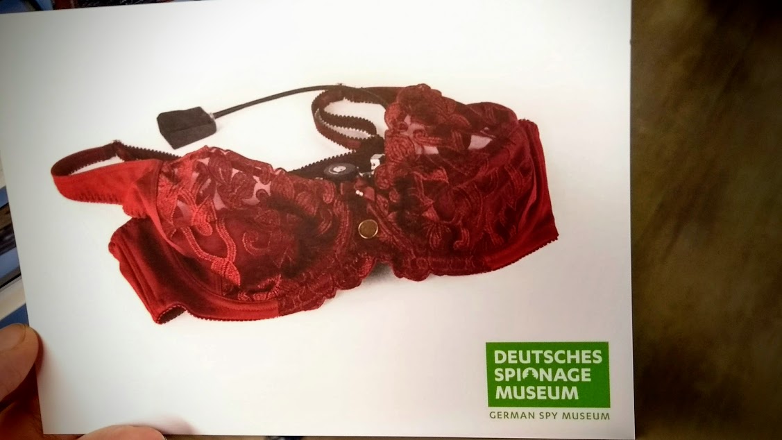 Reggiseno con microcamera per agenti segreti (cartolina del Museo dello Spionaggio, Berlino)