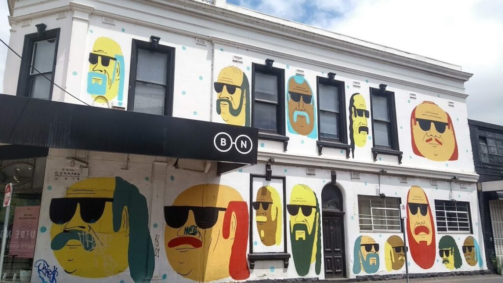 facciata di una casa dipinta con facce con occhiali da sole